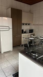 a kitchen with a white refrigerator and a table at Casa Aconchegante com 2 quartos in Araçariguama +8 photos