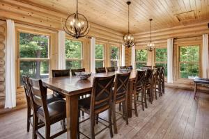 a dining room with a large wooden table and chairs at Fiddler Lake Resort - Elk 96 in Mille-Isles