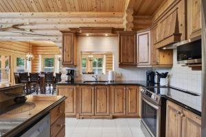 a kitchen with wooden cabinets and a counter top at Fiddler Lake Resort - Elk 96 in Mille-Isles
