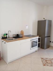 a kitchen with a sink and a refrigerator at Suite 93 in Mola di Bari +23 photos