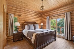 a bedroom with a bed in a log cabin at Fiddler Lake Resort - Elk 96 in Mille-Isles