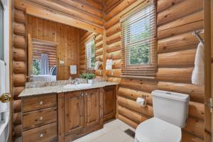 a log cabin bathroom with a toilet and a sink at Fiddler Lake Resort - Elk 96 in Mille-Isles +23 photos