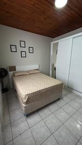 a bedroom with a bed and a wooden ceiling at Casa Aconchegante com 2 quartos in Araçariguama
