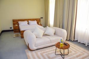 a living room with a white couch and a bed at N-line Residency Hotel in Arusha