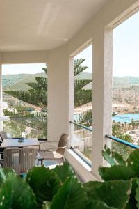 a room with a table and chairs and large windows at WG Hotel Lake View in Ksamil