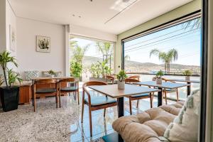 a living room with tables and chairs and a large window at WG Hotel Lake View in Ksamil