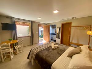 a bedroom with a large bed and a table at Morada Carmem in Praia do Rosa