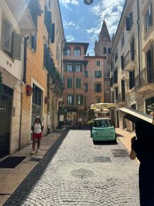 a green car parked in a street with buildings at ARENA D'INTORNO LUXURY e SUITES in Verona