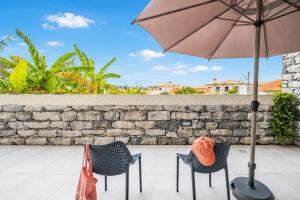 two chairs and an umbrella on a patio at Oceanea Apartment by Homie in Santa Cruz