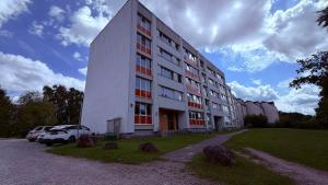 a large white building with cars parked in front of it at Kovarnu street apartment in Cēsis