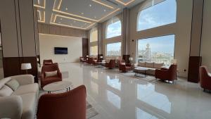 a lobby with chairs and tables and large windows at Eioraa Hotel فندق إيوراء in Khamis Mushayt