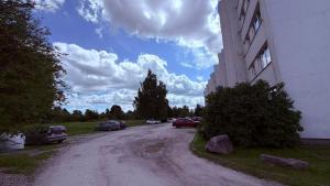 a street with cars parked on the side of a building at Kovarnu street apartment in Cēsis +2 photos