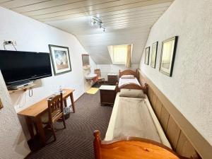 a room with a living room with couches and a tv at Hotel Bauernstube in Oberhausen