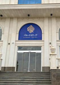 a building with a blue sign on the front of it at Eioraa Hotel فندق إيوراء in Khamis Mushayt