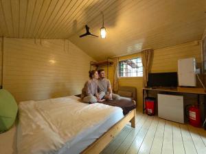 a man and woman sitting on a bed in a room at Mara by iVAVev in Eforie Sud