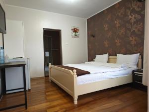 a bedroom with a bed with a floral wallpaper at Mara by iVAVev in Eforie Sud