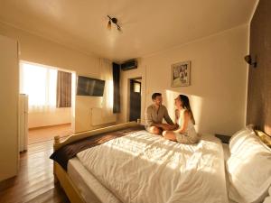 a man and woman sitting on a large bed at Mara by iVAVev in Eforie Sud +21 photos