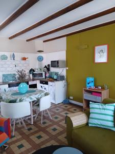a living room with a table and a kitchen at Rêve du Revert in Roz-sur-Couesnon