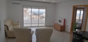 a living room with two chairs and a television at Résidence familiale le corail de chat Meriem in Sousse