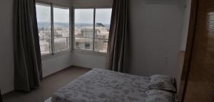 a bedroom with a bed and a large window at Résidence familiale le corail de chat Meriem in Sousse