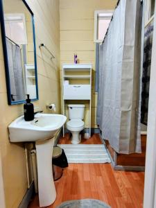 a bathroom with a white sink and a toilet at Her Home in Purranque