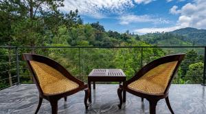 two chairs and a table on a balcony with a view at Ceylon tea resort Ella in Ella