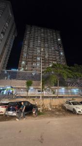 a man walking down a street in front of a tall building at Modern Studio With Balcony & Raod Facing View in Noida