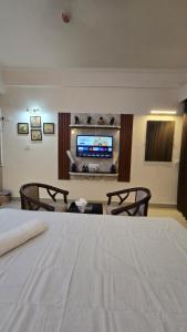 a hotel room with a bed and a flat screen tv at Modern Studio With Balcony & Raod Facing View in Noida +1 photo
