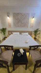 a large bed with two chairs and a table at Modern Studio With Balcony & Raod Facing View in Noida