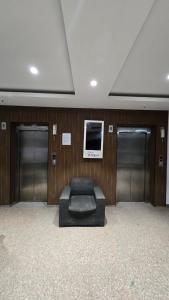a room with a couch in front of two doors at Modern Studio With Balcony & Raod Facing View in Noida
