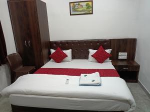 a bedroom with a large bed with red pillows at Hotel sphatic in Chitrakoot