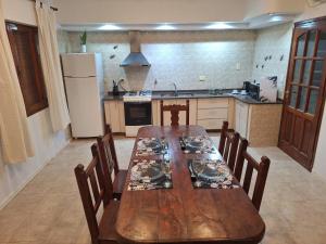 a kitchen with a wooden table with chairs and a refrigerator at Petit Margaret in Santa Rosa +8 photos