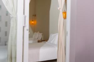a bedroom with a white bed and a window at Sonata 44 Hotel Laureles in Medellín