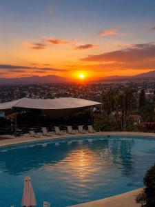 a swimming pool with the sunset in the background at Lol-ha glamp in Temixco