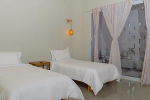 a bedroom with two beds and a window at Sonata 44 Hotel Laureles in Medellín