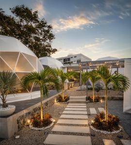 a courtyard with palm trees in front of a building at Lol-ha glamp in Temixco