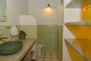 a bathroom with a green sink and a toilet at Sonata 44 Hotel Laureles in Medellín +134 photos