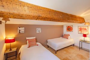 two beds in a room with two lamps at Mas Du Pont Rouge in Sylvéréal