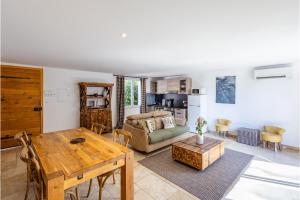 a living room with a table and a couch at Mas Du Pont Rouge in Sylvéréal