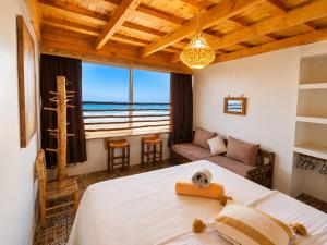 a bedroom with a bed and a view of the ocean at Miramar Surf Anza in Agadir