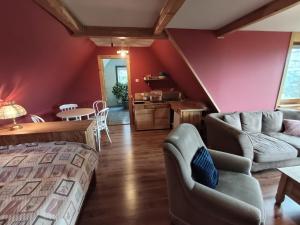 a bedroom with a bed and a couch and a table at Kitajówka in Bańska Wyżna +4 photos