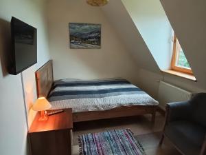 a small bedroom with a bed and a desk and a window at Kitajówka in Bańska Wyżna