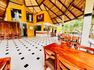 a restaurant with a wooden table and chairs at Hosteria Chuquitos - Chalupas in Tena