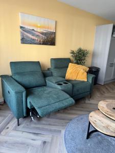a living room with a couch and a chair at Bed & Wellness Chinel Luxe vakantiehuis met Sauna's en Bubbelbad in Sint Annaland
