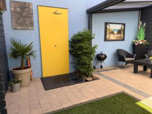 a yellow door on the side of a building at Bed & Wellness Chinel Luxe vakantiehuis met Sauna's en Bubbelbad in Sint Annaland