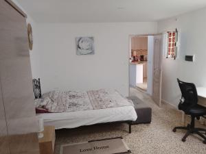 a bedroom with a bed and a desk and a chair at Studio in La Goulette