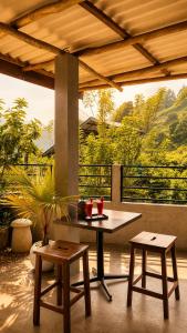 a table and two stools on a patio with a view at Greenland Villa Ella in Ella