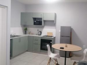 a small kitchen with a table and a refrigerator at Your Exclusive PMB Escape in Pietermaritzburg