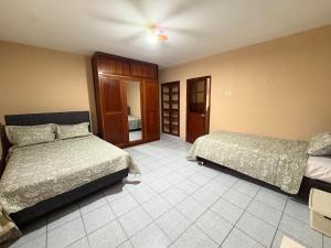 a hotel room with two beds in a room at CIX HOUSE, Casa completa de 3 pisos in Chiclayo