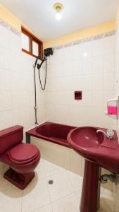 a bathroom with a red toilet and a bath tub at CIX HOUSE, Casa completa de 3 pisos in Chiclayo